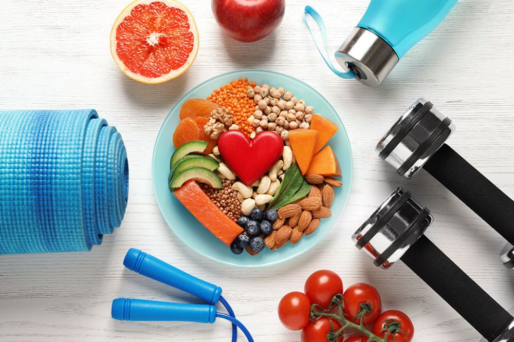 Foto: Bowl mit Obst darum angeordnet liegen Fitnessgeräte